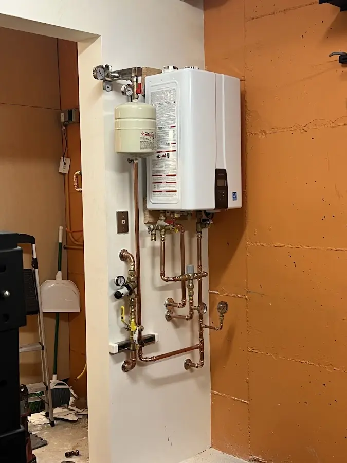 Plumbing technician inspecting water heater connections in Ellisville